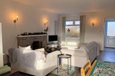 Glynsk Holiday Home. Cosy living room with two sofas and open fire.