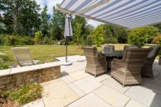 Brittas Bay Holiday Park No. 7. Paved patio in private garden. Awning and wicker garden furniture in mature garden. 