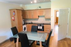 Heyward Mews Holiday Homes, Modern bright kitchen, wooden flooring. Dining table seating for four. 