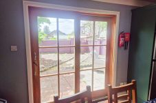 Dingle Town Holiday Home. Dining table seating six, patio door to garden. 
