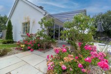 Brittas Bay Holiday Park No. 7. Paved patio with awning and garden furniture. Mature bright floral garden. 